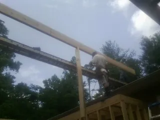 Carpenter setting a ridge beam over a new addition frame — Ice Dam Removal by Roofing Brothers in Duarte