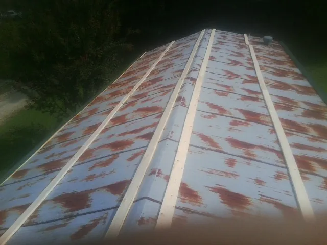 Rusted metal roof panels with new wood purlins before replacement — Storm Damage Roof Repair in Duarte by Roofing Brothers
