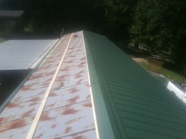 Old rusted panels beside newly installed green metal roofing — Wind Damage Roof Repair by Roofing Brothers in Duarte