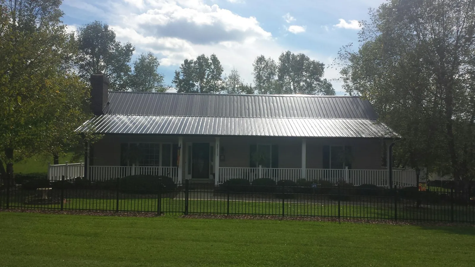 Gray metal roof on a brick ranch with a full width front porch — Gutter Guard Installation work by our crew in Duarte