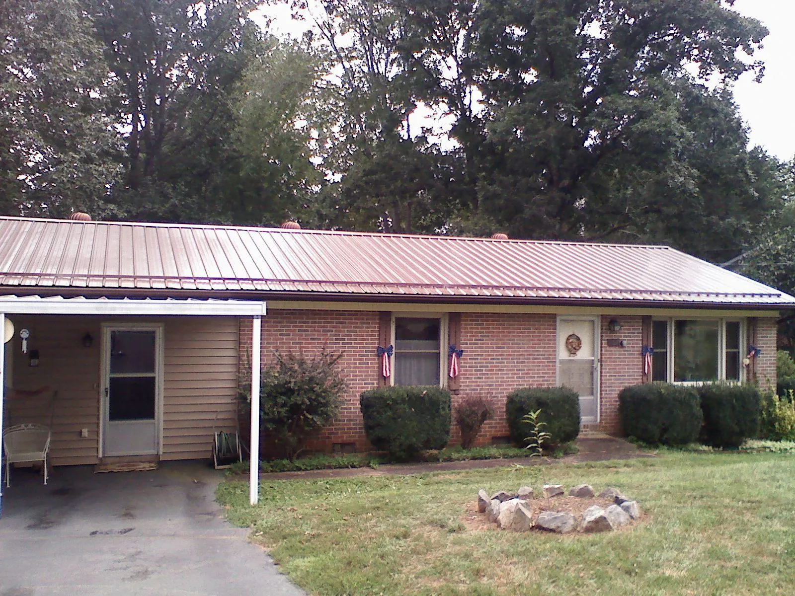 Bronze metal roof and carport on a brick ranch home — Roof Repair work by our crew in Duarte